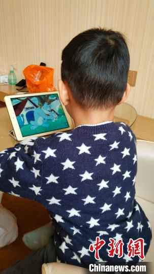 图为被隔离的密切接触者4岁的小男孩小东(化名)在乖巧的看动画视频 惠东县委宣传部供图
