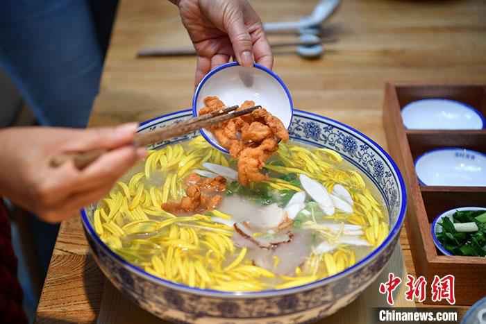 图为3月18日，食客正在放入各种配菜。/p中新社记者 刘冉阳 摄