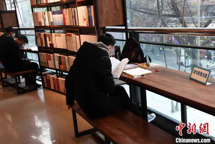 资料图：图为重庆书城恢复营业，市民戴着口罩阅读。　周毅 摄