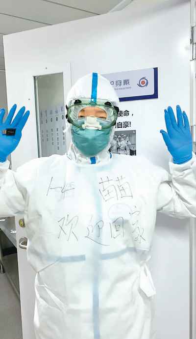 图为一名护理人员在防护服上写下“欢迎回家”的字样。小汤山护理人员供图
