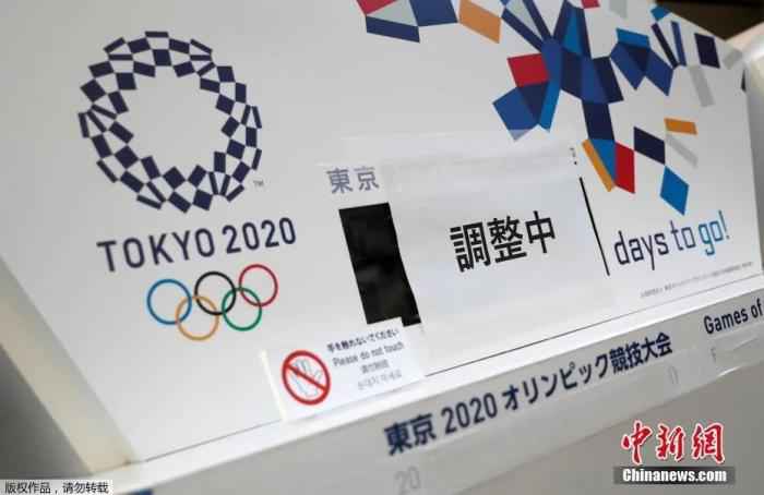 3月25日，在日本东京中央区，一间写字楼内的原本显示东京奥运会倒计时的电子屏被贴上了“正在调整”，下方奥运会的原定举办日期也被遮挡了起来。