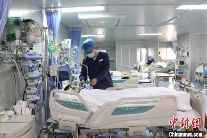 图为柳州市人民医院ICU男护士唐天泽在护理病患。　林馨 摄