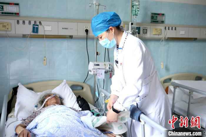 在柳州市工人医院，梁艳冰在帮病人整理被子。　朱柳融 摄