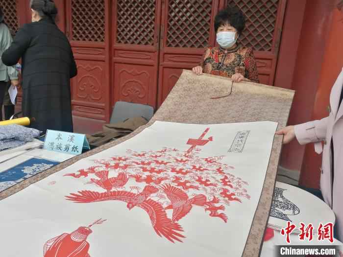 非物质文化遗产传承人在展览上展示其剪纸作品。　李晛 摄