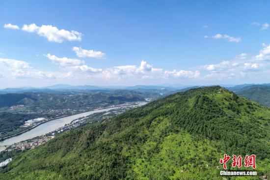 航拍镜头下的广东省梅州市明珠冶炼厂旧址与称子岌山。10多年前，称子岌山由于受到明珠冶炼厂排放物的污染，导致长期荒山秃顶，岩石裸露。目前，当地政府关闭冶炼厂，对山体进行生态修复，称子岌山重新披“绿装”，植被已基本恢复。/p中新社记者 陈骥旻 摄