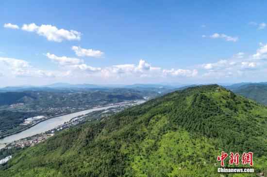 航拍镜头下的广东省梅州市明珠冶炼厂旧址与称子岌山。10多年前，称子岌山由于受到明珠冶炼厂排放物的污染，导致长期荒山秃顶，岩石裸露。目前，当地政府关闭冶炼厂，对山体进行生态修复，称子岌山重新披“绿装”，植被已基本恢复。/p中新社记者 陈骥旻 摄