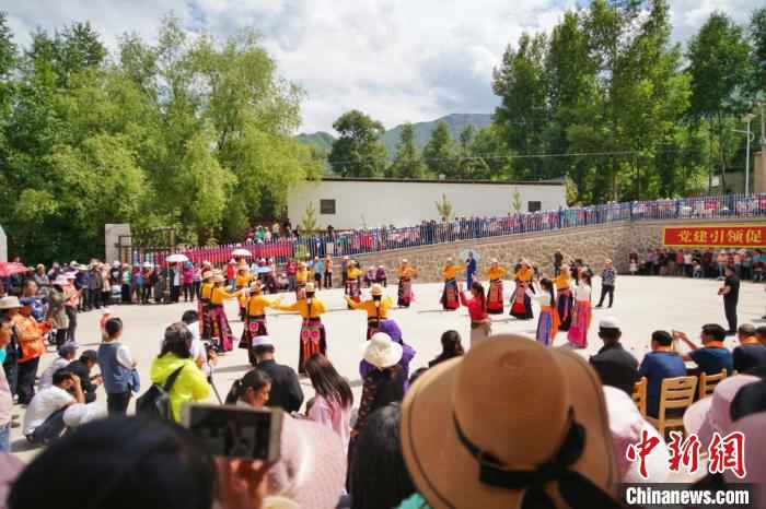 图为山庄村的村民们在广场上跳锅庄舞，前来观看的村民围满了广场。　文思睿 摄