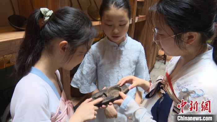 参加研学游活动的小学生们正在研究徽州饼模 刘鸿鹤 摄