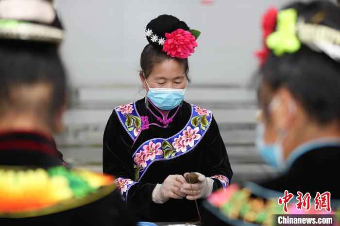 一位苗族妇女在包五彩粽。　瞿宏伦 摄