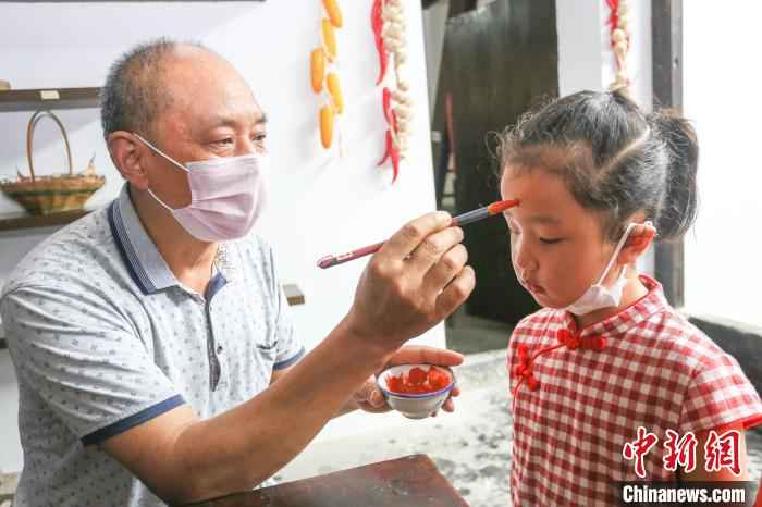 孩子接受老人的额点雄黄 王康荣 摄