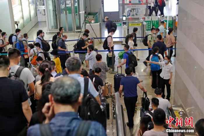 资料图：铁路上海虹桥站工作人员引导旅客安全有序离开车站。 殷立勤 摄