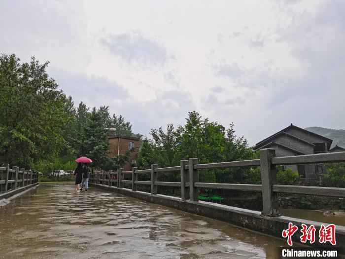 图为游客雨中漫步在通往西河湾村的小道上。　李贵刚 摄