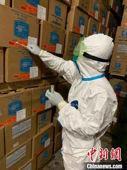 检测人员在厄瓜多尔进口冻南美白虾产品外包装上取样。　宁波卫健委供图