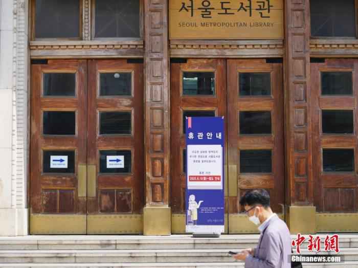 6月23日，一位韩国首尔市民经过首尔市立图书馆门前，该图书馆贴出闭馆通知。近来，包括韩国首尔、仁川、京畿道在内的首都圈确诊病例持续增加。
/p中新社记者 曾鼐 摄