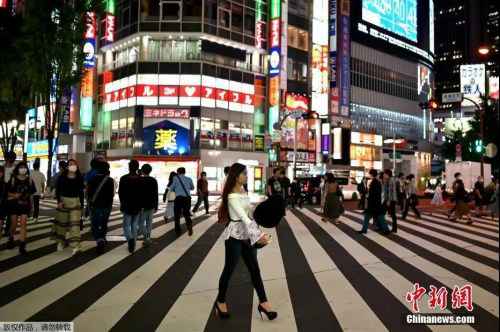 资料图：5月15日，日本解除紧急事态宣言，人们穿过东京新宿区的一条街道。（/p中新网）