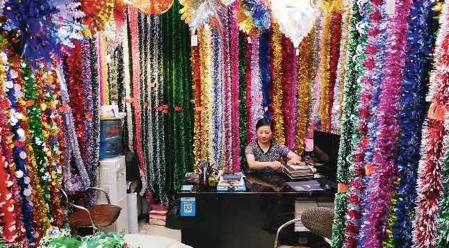 

7月11日中午，陈爱玲在自家批发圣诞喜庆用品的商铺内。摄影/中国新闻周刊记者 杜玮