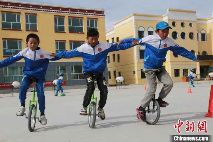 图为乡村学校少年宫的孩子们正在骑独轮车。　才让本 摄