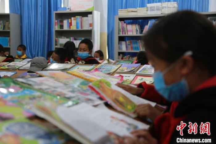 图为乡村学校少年宫的孩子们在阅览室读书。　才让本 摄