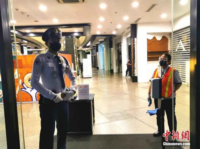 当地时间8月13日，在菲律宾首都马尼拉CBD马卡蒂绿带商圈GREENBELT5商场，保安和负责测量体温的工作人员佩戴口罩和面罩上岗。