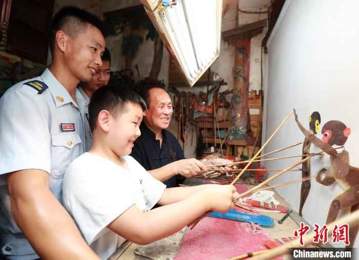 图为秦礼刚正在讲授皮影戏知识 王方 摄