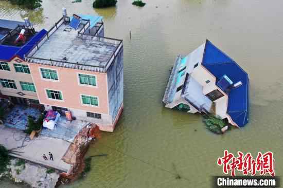 江西鄱阳县油墩街镇荻溪村，一栋三层高的楼房被洪水侵袭整体倾斜倒下。　刘占昆 摄