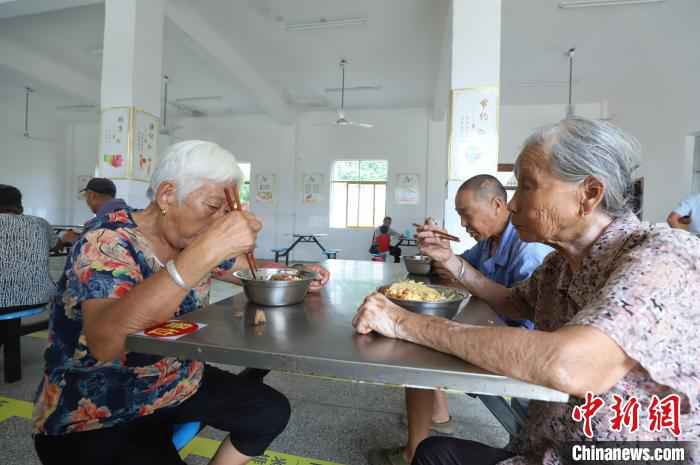 被转移的村民在安置点食堂用餐。　袁昕 摄