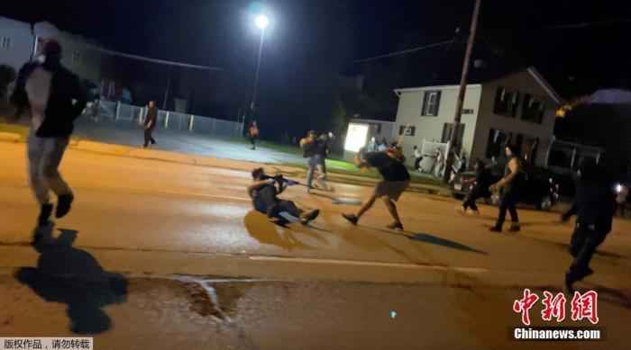 当地时间8月25日，美国威斯康星州基诺沙，在非裔男子雅各布·布莱克遭警察多次开枪射击引发示威抗议中，一名男子举枪射击。