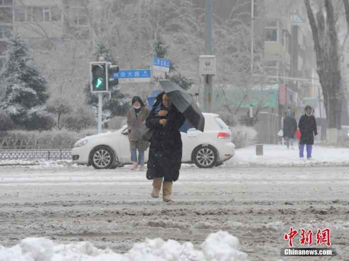 资料图：11月19日，吉林长春，市民冒雪出行。当日，吉林长春遭遇暴雪天气。 /p中新社记者 刘栋 摄