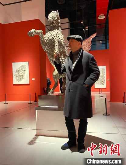 图为傅榆翔与作品《腾跃》雕塑合影。受访者供图