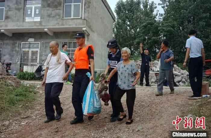 资料图：洪水来临前，江西九江市彭泽县棉船镇民众在民警帮助下转移。周骄 摄