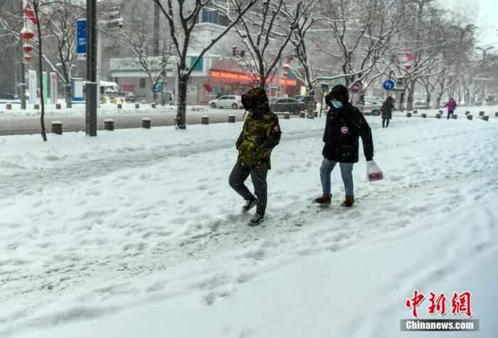 资料图：民众冒雪外出。
/p中新社记者 刘新 摄