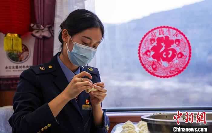 图为兰州客运段乘务人员在餐车内包饺子、过新年。　田多伟 摄