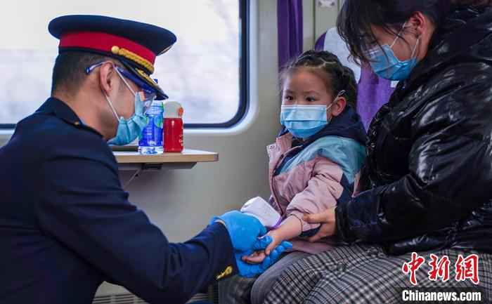 图为兰州客运段乘务人员为小旅客测温，做好旅客列车常态化疫情防控工作。　田多伟 摄