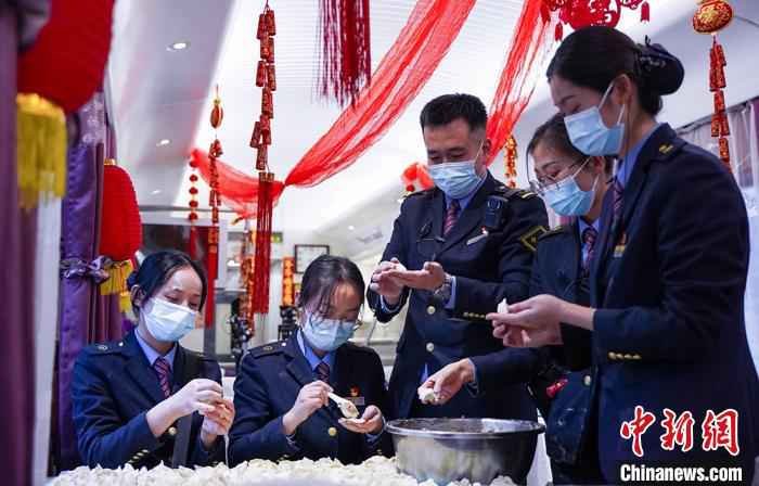 图为兰州客运段乘务人员在餐车内一起包饺子。　田多伟 摄