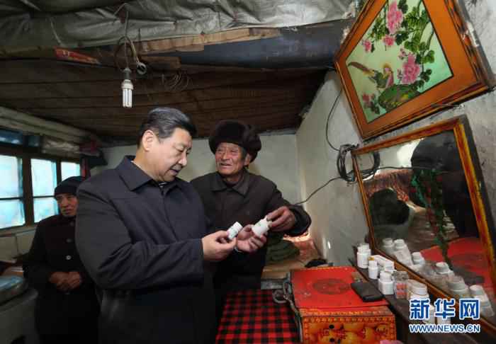 这是2012年12月30日，习近平在龙泉关镇骆驼湾村困难群众唐荣斌家，详细询问身体有病的唐荣斌(右)日常服药情况。新华社记者 兰红光 摄