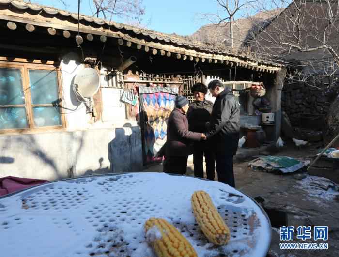 这是2012年12月30日，习近平在龙泉关镇骆驼湾村，与困难群众唐荣斌(中)夫妇握手告别。新华社记者 庞兴雷 摄