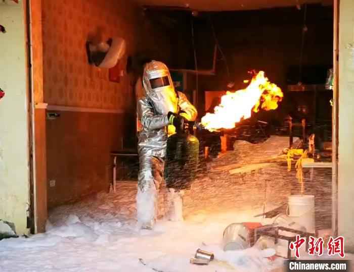 消防员火中徒手拎出着火煤气罐。湖北咸宁消防供图