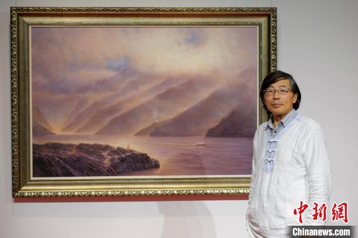 4月1日，“景向——崔毅风景油画作品展”在重庆开幕。图为崔毅与他的油画作品。　何蓬磊 摄