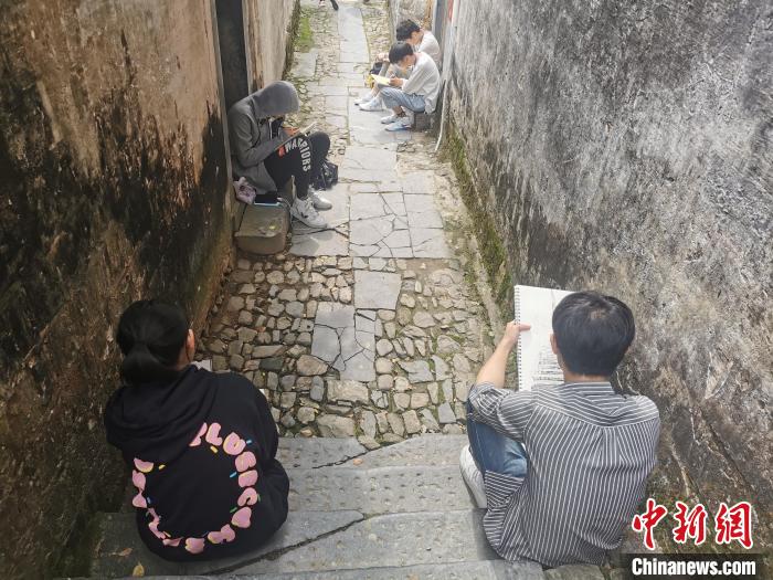 在安徽省黄山市黟县碧阳镇南屏村 学生们正坐在巷口写生。　储玮玮 摄