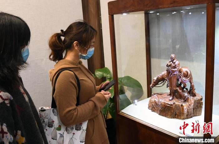 由中国工艺美术大师林学善创作的木雕精品《创业艰难百战多》吸引观众观看。　记者刘可耕 摄