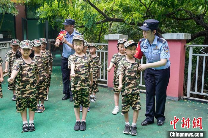 民警组织幼儿园儿童开展夏令营队列训练。　泱波 摄