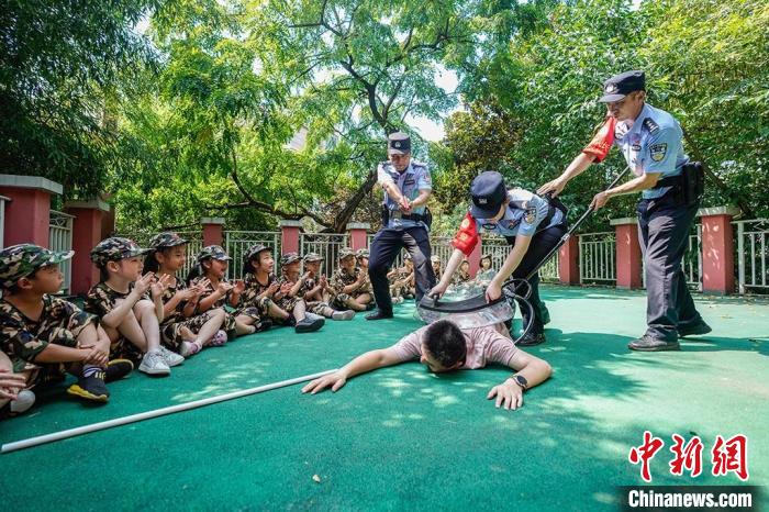 民警为孩子们表演“抓坏人”。　泱波 摄