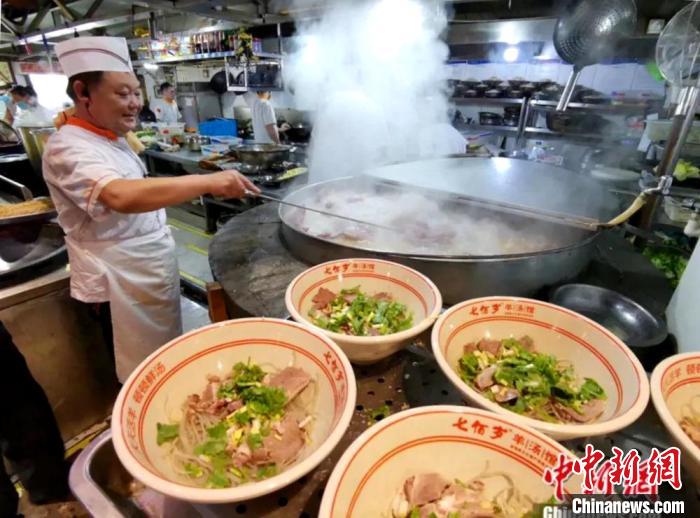厨师用大锅烹制羊肉汤，迎接众多来店喝羊肉汤的市民。　葛勇 摄