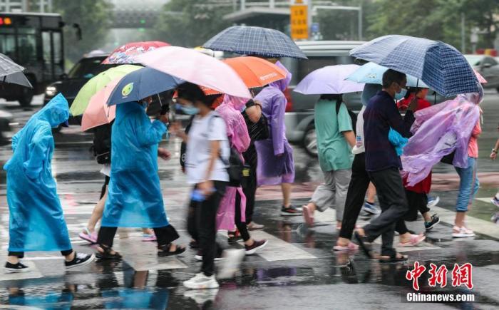 7月12日，北京朝阳区团结湖附近，民众通过路口。从11日夜间开始，北京迎来入汛以来最强降雨天气。 /p中新社记者 贾天勇 摄