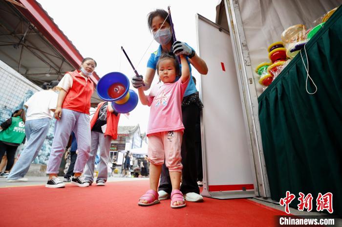15日，中国潘家园第一届非遗文化节在北京潘家园旧货市场开幕。图为一名女孩学习抖空竹。　/p中新社记者 富田 摄