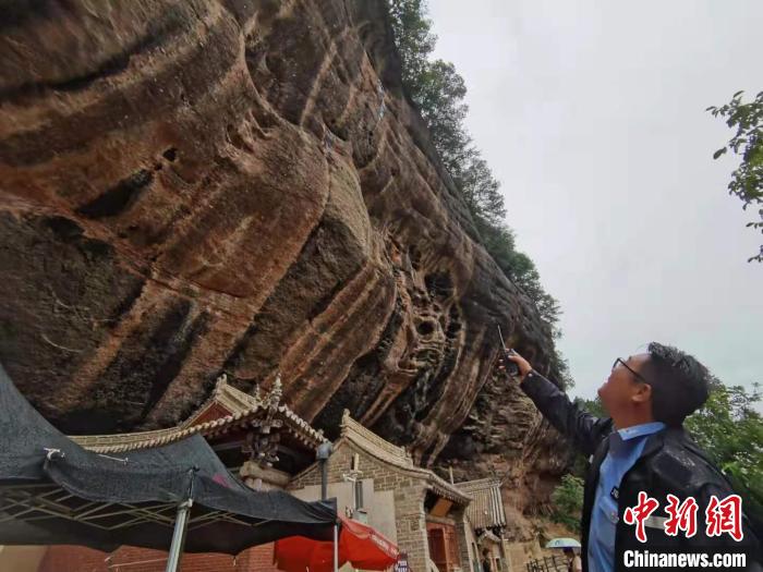 图为胡波冒雨巡山，进行山体安全检查。　张婧 摄