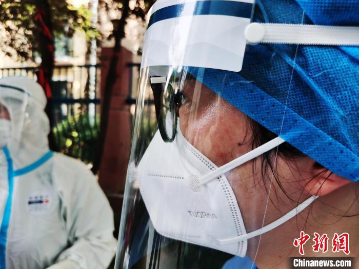 8月1日郑州遭遇高温天气，做核酸检测的医护人员脸上布满汗水。　董楠峰 摄