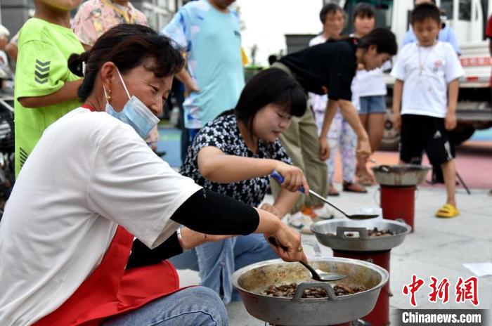 丰收节里现场煎制金蝉美食以供游客品尝。　朱志庚 摄