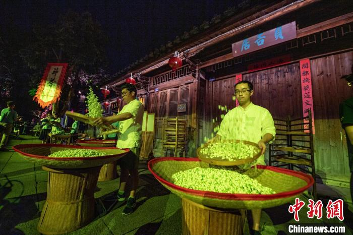 福州茉莉花茶窨制工艺第四代传承人林碧峰(左)展现筛花技艺。　张斌 摄