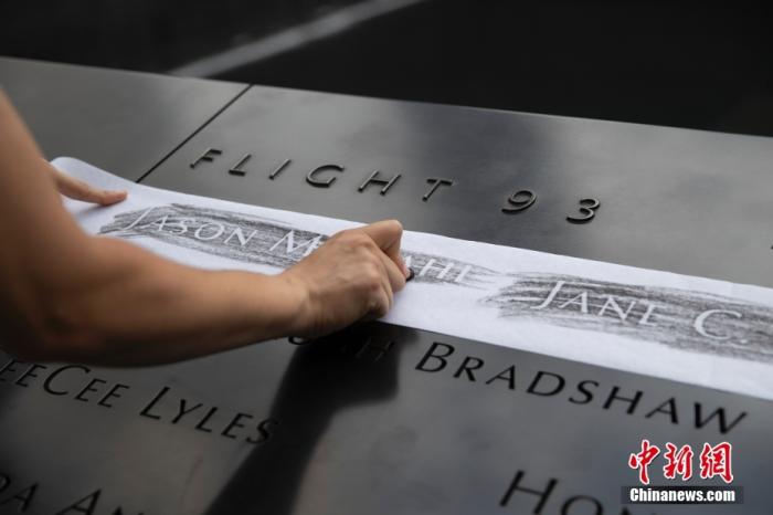 当地时间2021年9月8日，美国纽约归零地“9·11”世贸遗址工作人员在恐袭遇难者姓名石台上制作拓片给相关家庭。 /p中新社记者 廖攀 摄